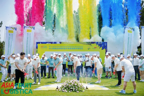 People are playing golf in front of an Asia Fruit Logistica banner.