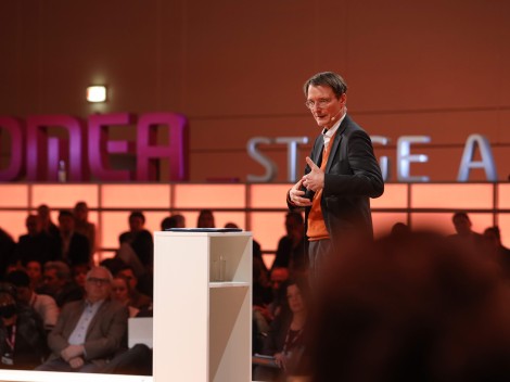 Karl Lauterbach steht als Redner an einem Pult 