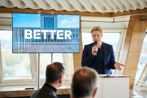 Franziska Giffey steht neben einem Monitor, auf dem 'Better' steht, dahinter die Messe.