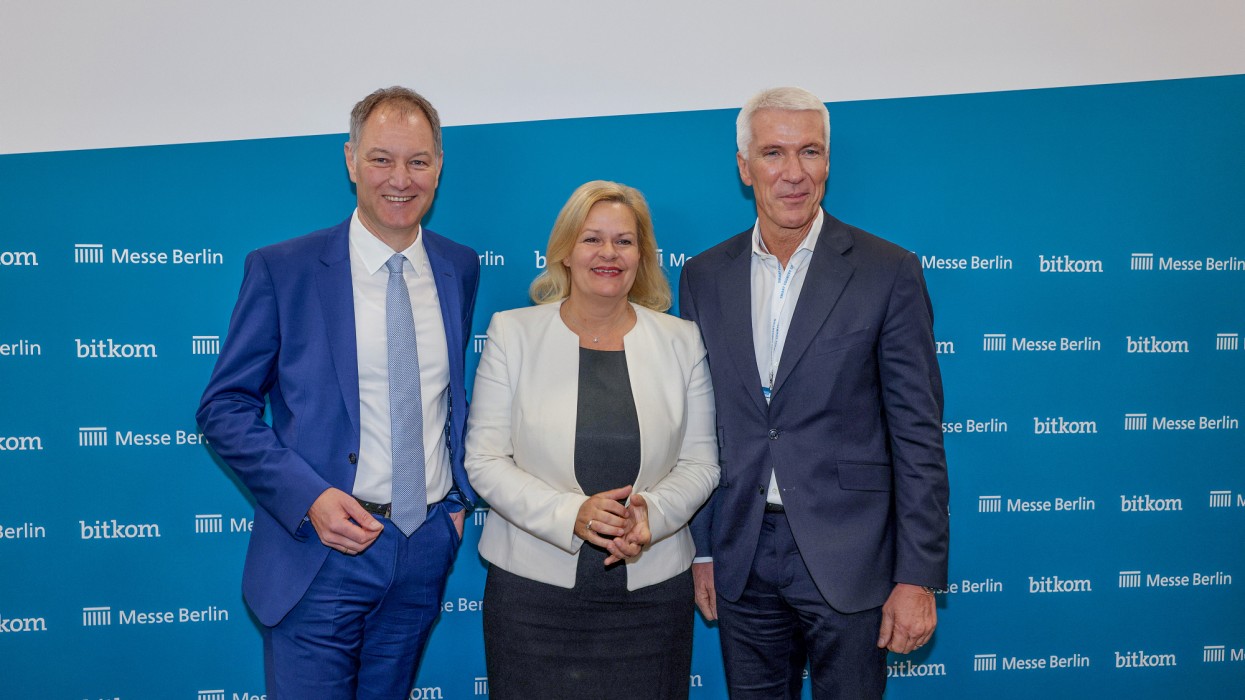 Mario Tobias steht neben Nancy Faeser und Ralf Wintergerst des Bitkom e.V. Hinter ihnen steht eine Logowand mit Messe Berlin Logos und Bitcom Logos